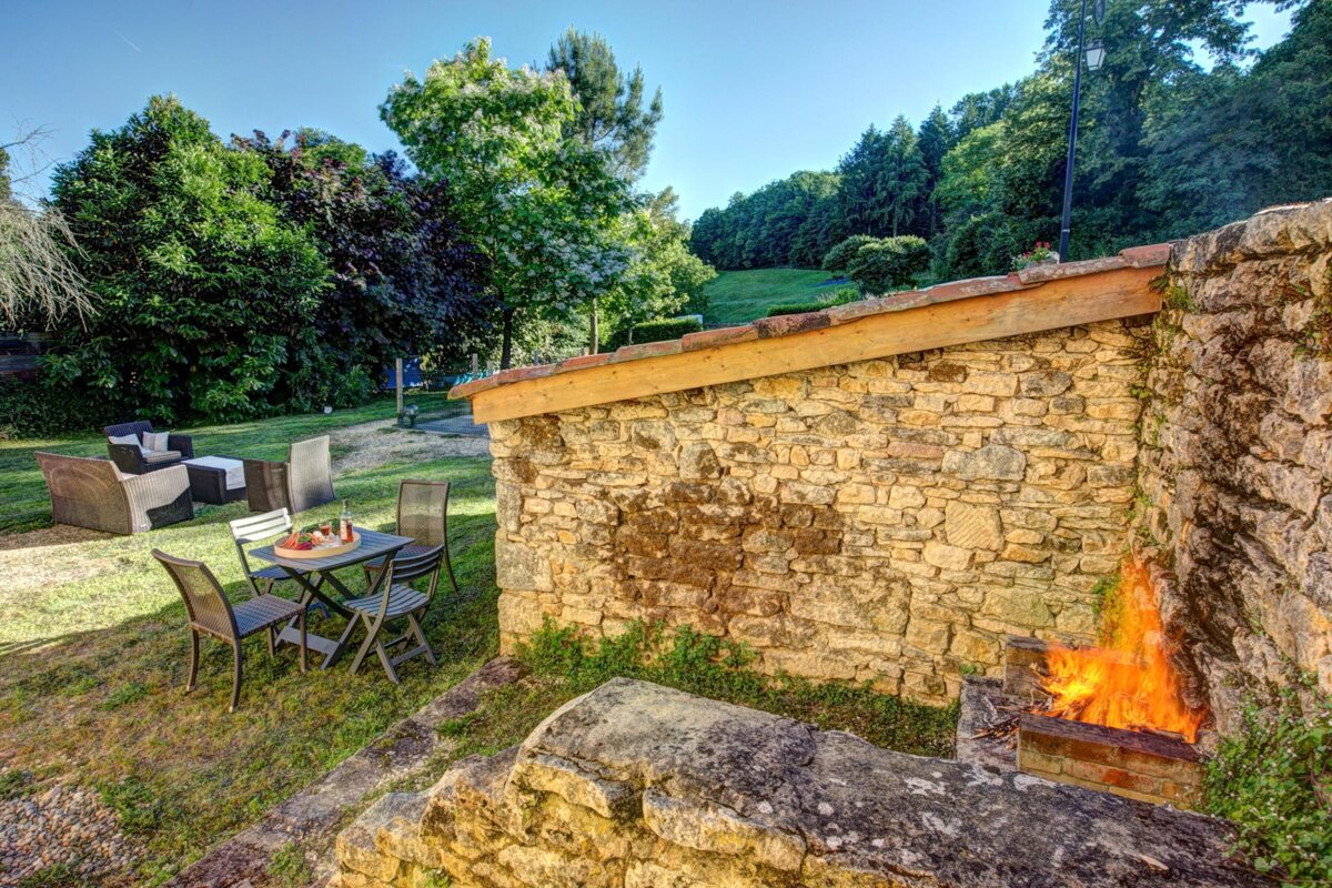 A stone wall with a table and chairs in front of it