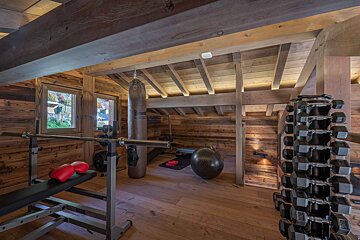 A treadmill in a wooden room next to a hot tub