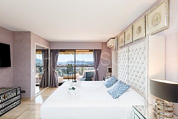 A bedroom with a large bed and a sliding glass door