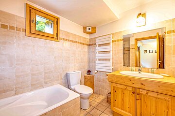 A bathroom with a toilet a sink and a window