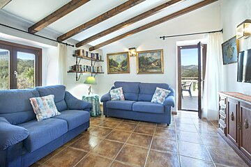 A living room with a blue couch and two paintings on the wall
