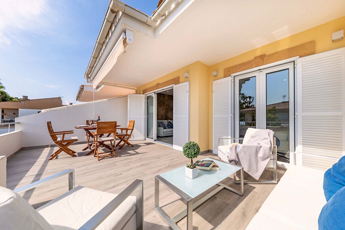 A balcony with a table and chairs and a book on the table