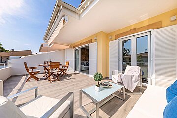 A balcony with a table and chairs and a book on the table
