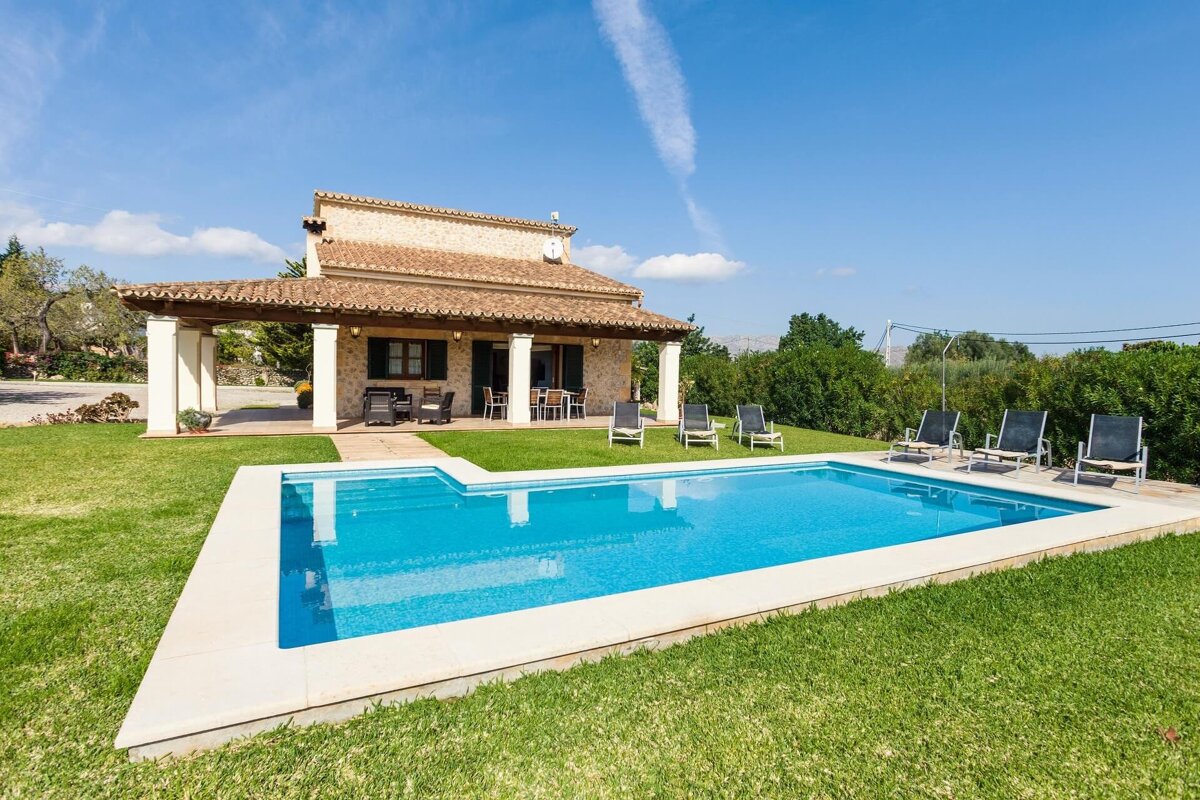 A house with a large swimming pool in front of it