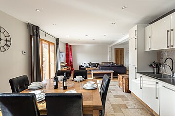 A bottle of wine sits on a table in a kitchen