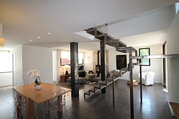 A living room with a table and chairs and a staircase