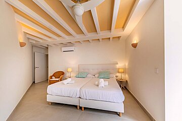 A bedroom with two beds and a ceiling fan