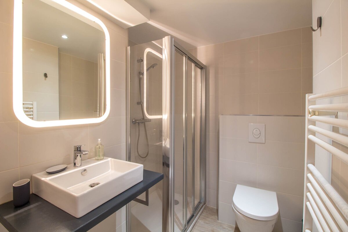 A bathroom with a toilet a sink and a mirror