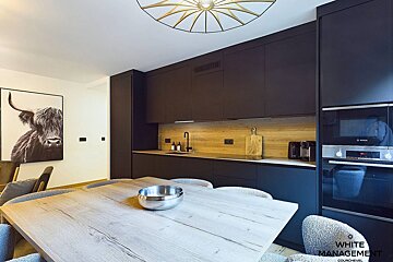 A kitchen with black cabinets and a bosch oven