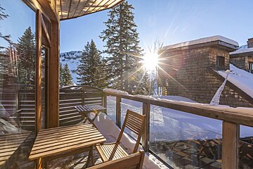 A balcony with a view of snowy trees and mountains