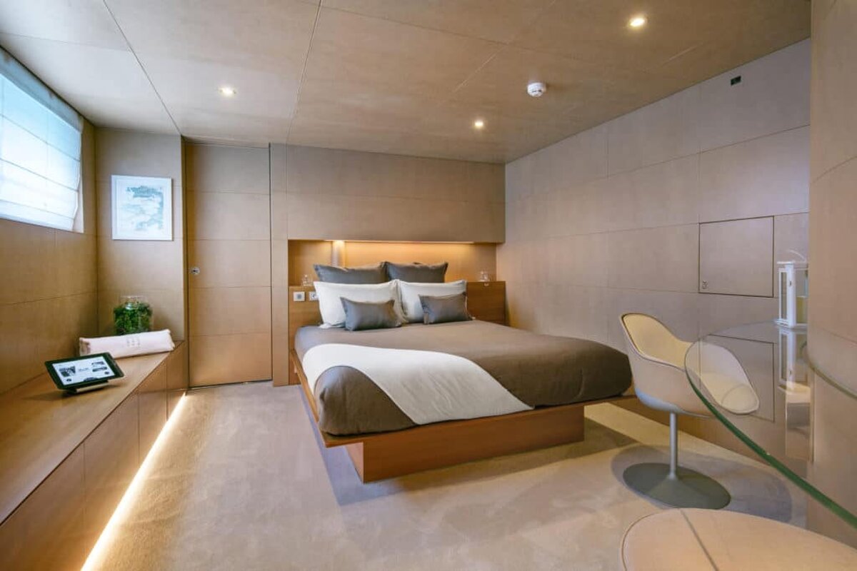 A bedroom with a large bed and a white chair