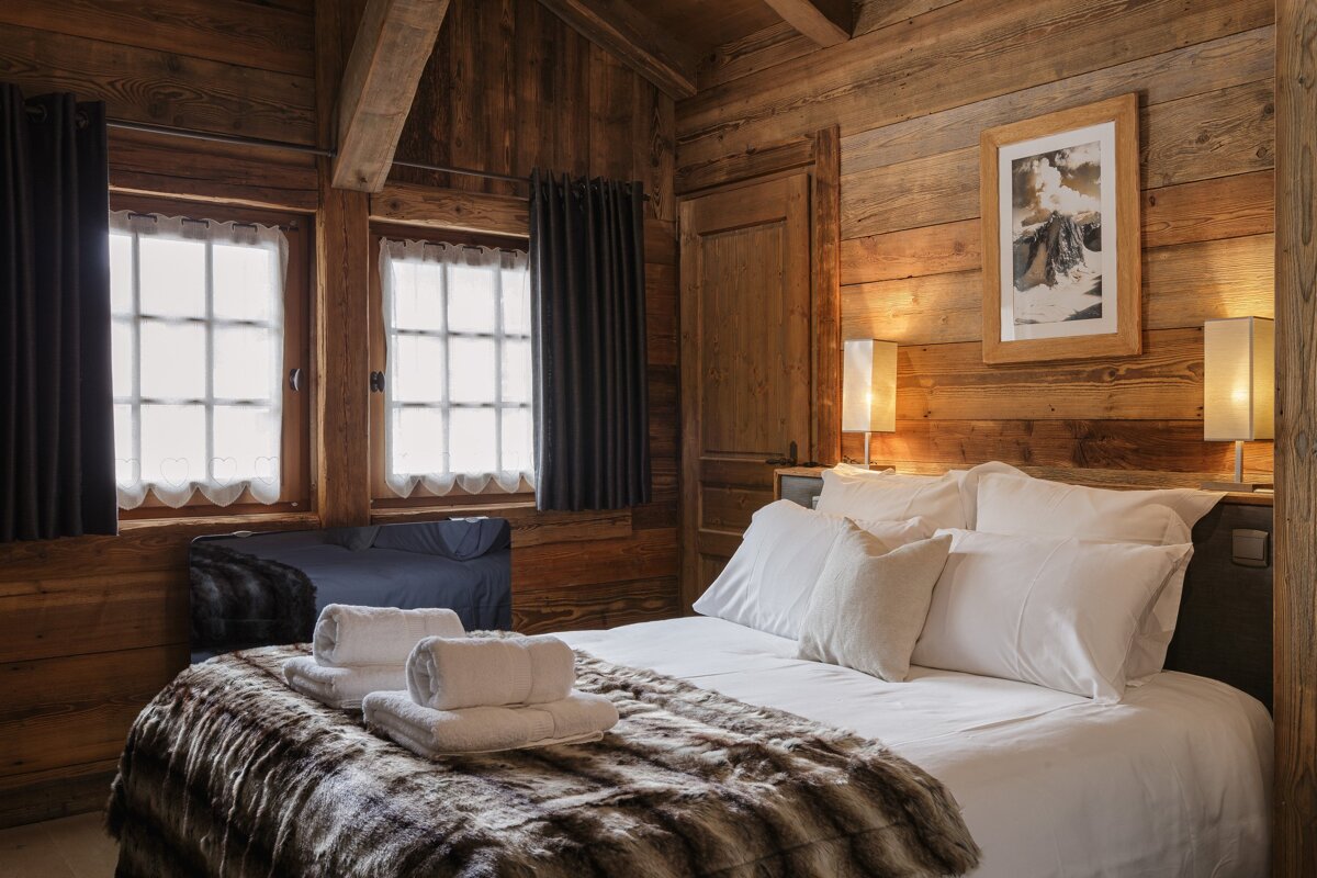 A bedroom with a bed and a picture on the wall