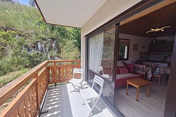 A balcony with two chairs and a couch