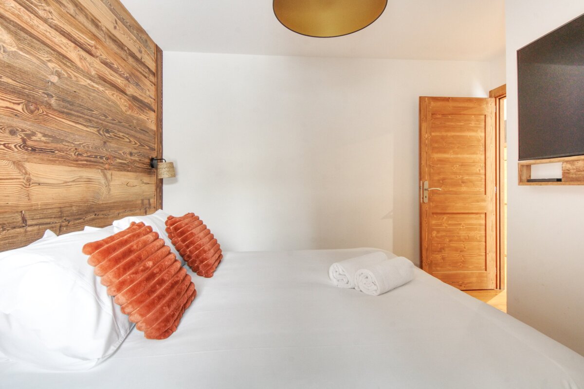 A bedroom with a wooden headboard and a bed