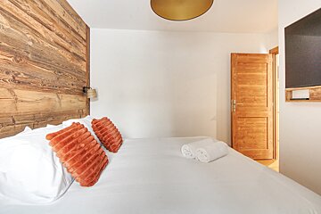 A bedroom with a wooden headboard and a bed