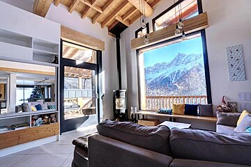 A living room with a large window looking out to the mountains