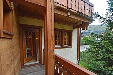 A wooden balcony with a view of the mountains