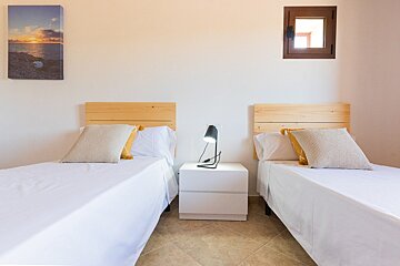 A bedroom with two beds and a picture on the wall