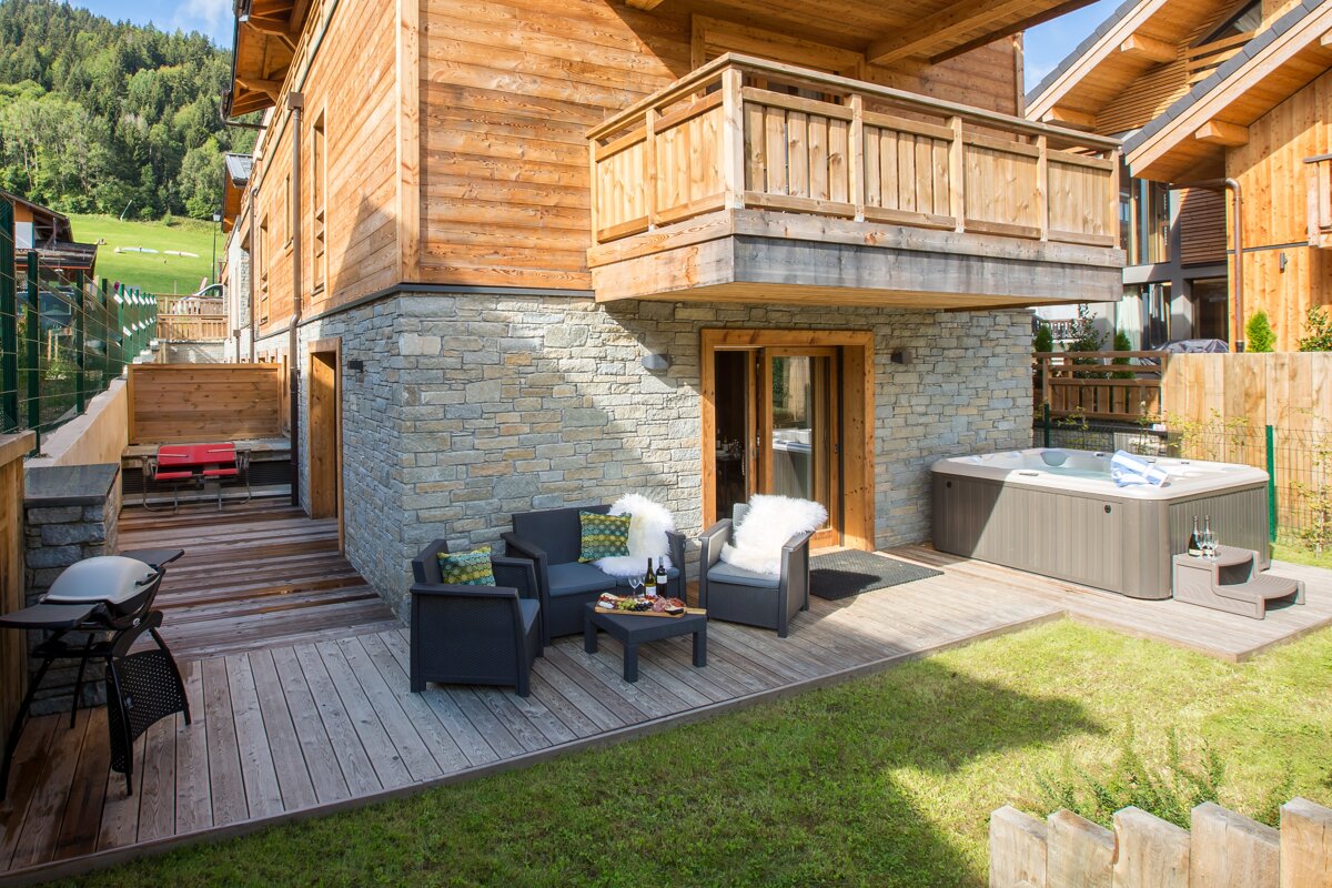A wooden house with a hot tub in front of it