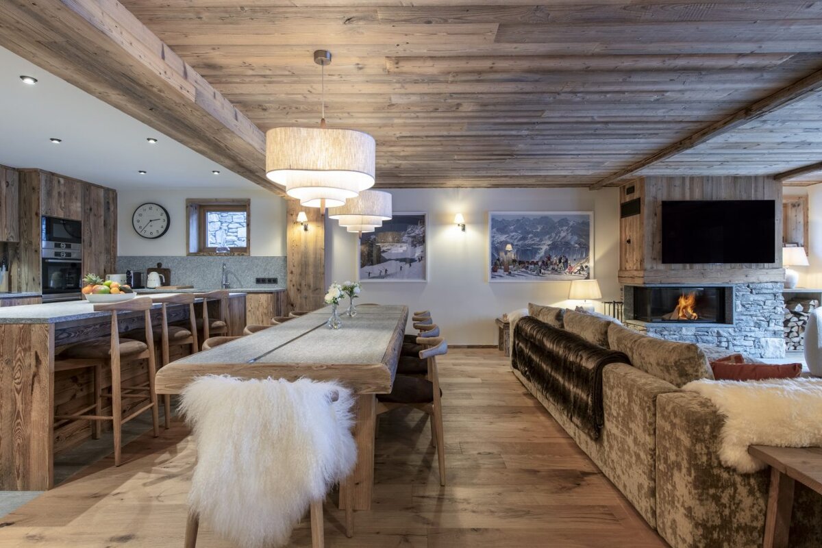 A living room with a long table and a fireplace