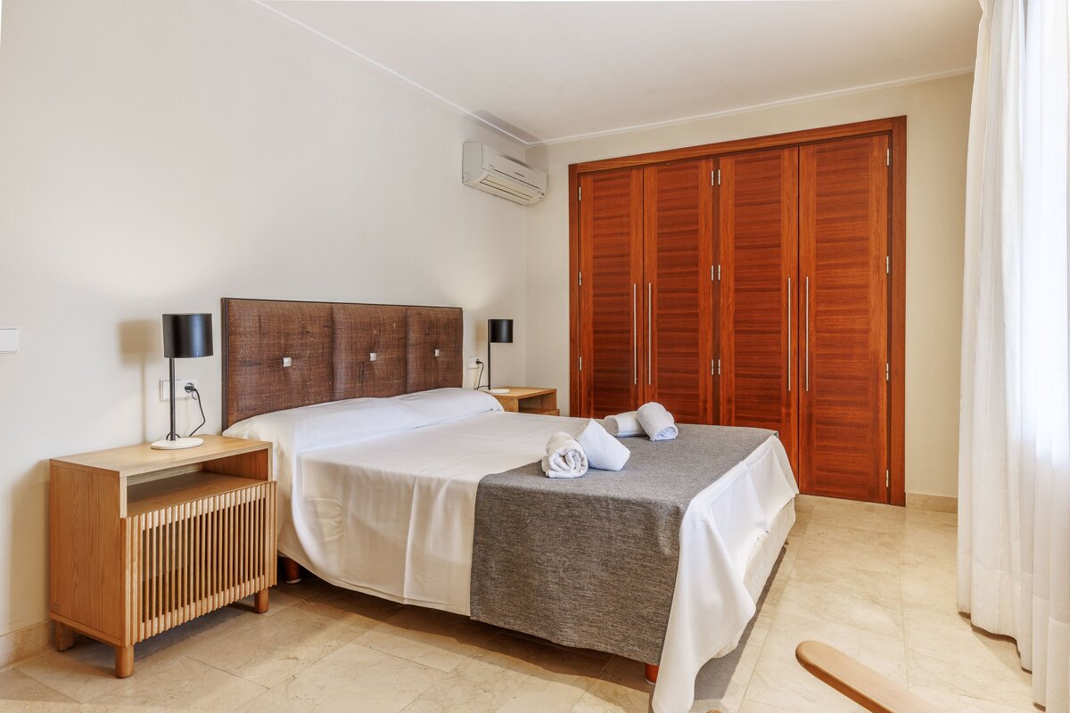 A bedroom with a large bed and a closet