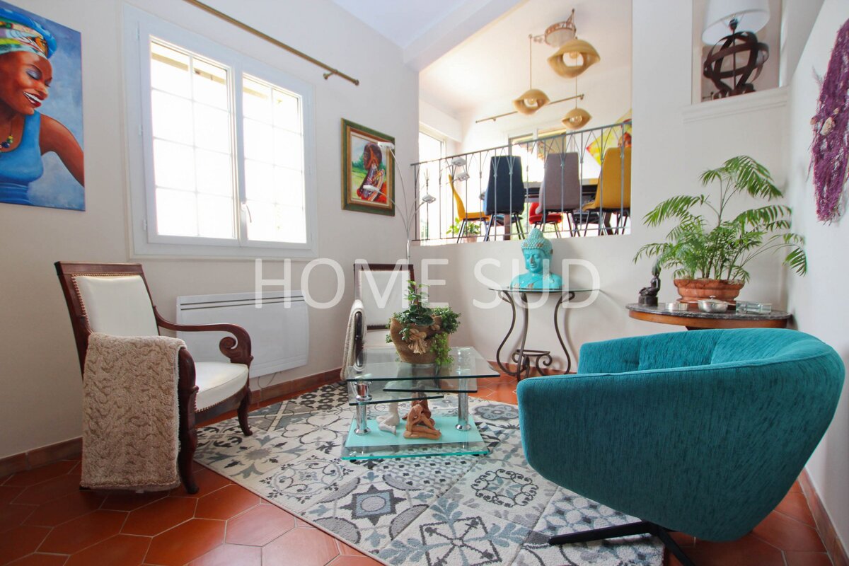 A living room with a blue chair and a glass coffee table that says homesud