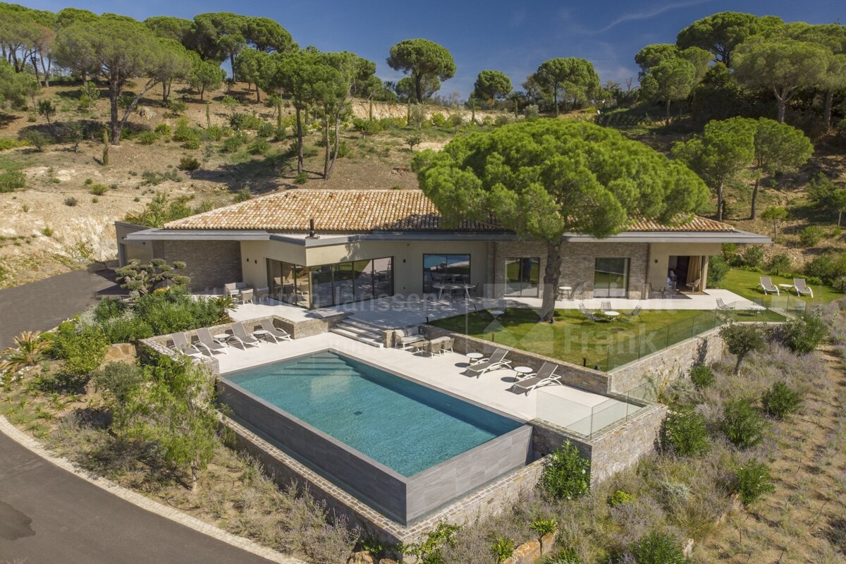 An aerial view of a house with a large swimming pool