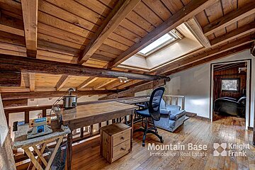 A wooden room with a desk and chair and the words mountain base immobilier real estate on the bottom
