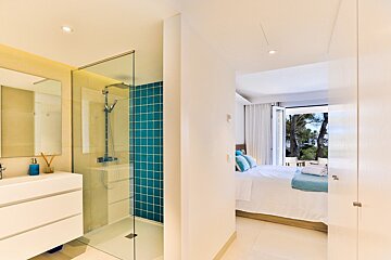 A bathroom with blue tiles and a walk in shower