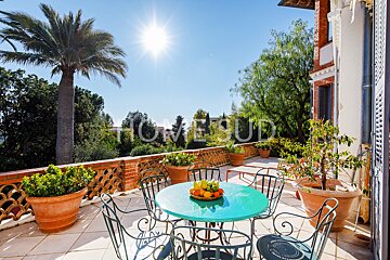 A table and chairs on a balcony with a sign that says homebud