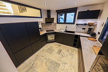 A kitchen with black cabinets and white counter tops