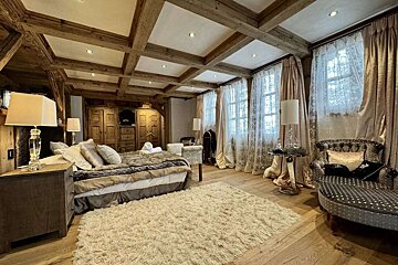 A bedroom with a coffered ceiling and a bed