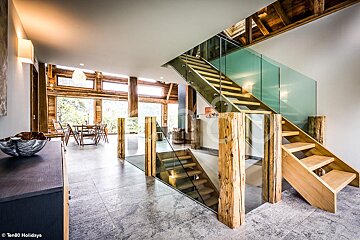 A staircase with a glass railing and wooden steps