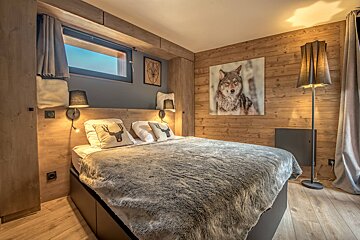 A bedroom with a picture of a wolf on the wall
