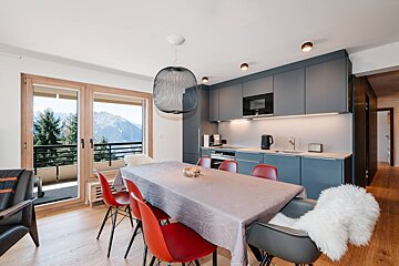 A kitchen with a table and chairs and a view of the mountains