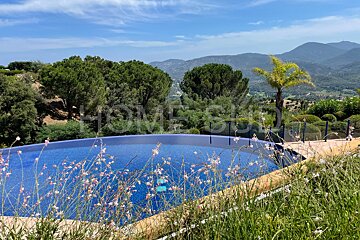 A swimming pool surrounded by tall grass with the word home on the bottom