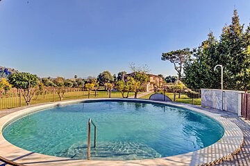 A large swimming pool with a house in the background