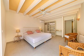 A bedroom with two beds and a ceiling fan