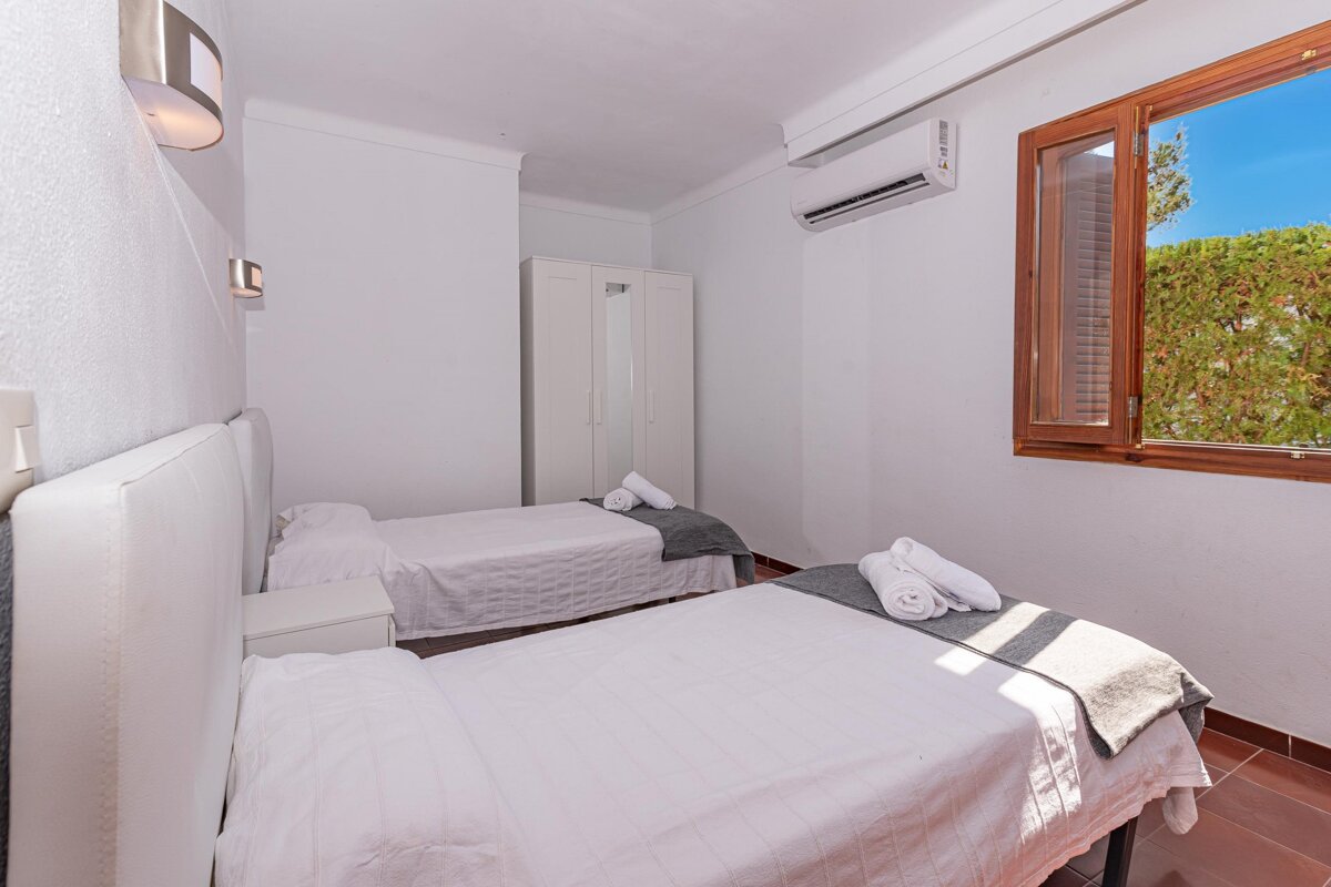 A bedroom with two twin beds and a window