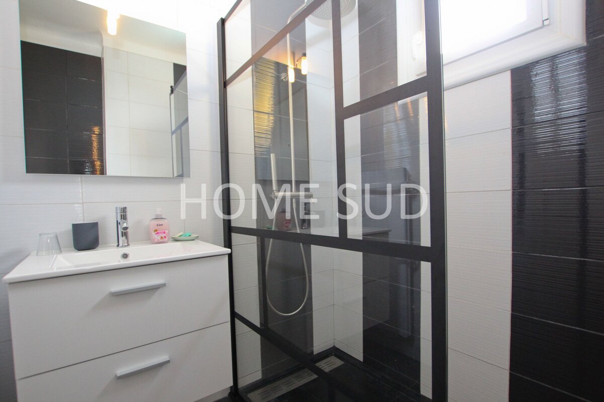 A bathroom with black and white tiles and the words home sud on the wall