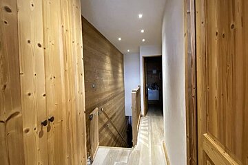 A hallway with wooden walls and stairs in a house