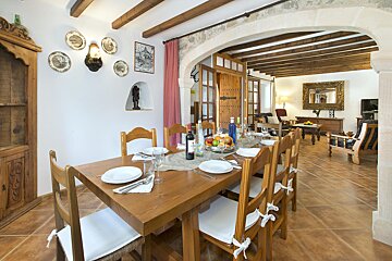 A dining room table with a bottle of wine on it