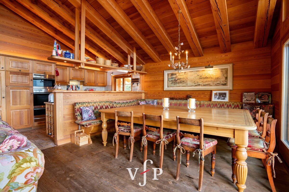 A wooden dining room with a table and chairs and a sign that says vjp