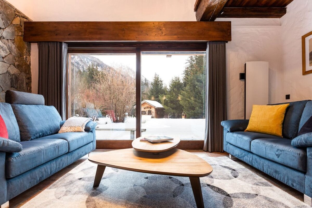A living room with two blue couches and a wooden coffee table
