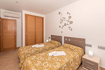 A bedroom with two twin beds and a nightstand