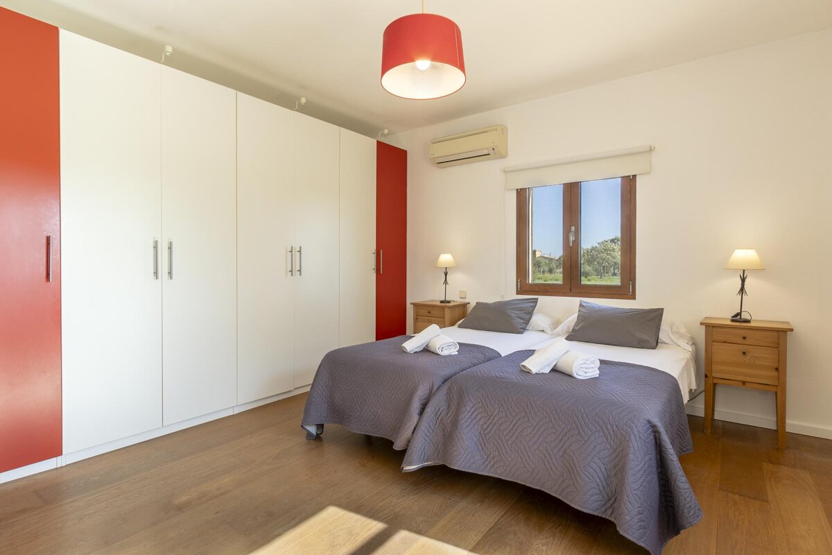 A bedroom with two beds and a window