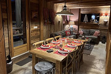 A dining room table with plates and candles on it