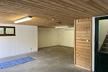 An empty garage with a green door and stairs