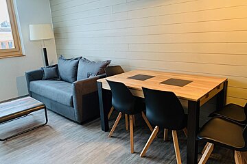 A living room with a couch a table and chairs