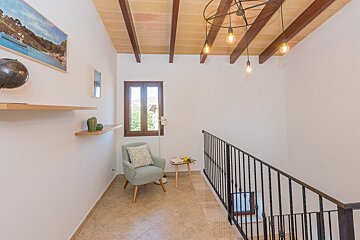 A staircase with a chair and a picture on the wall